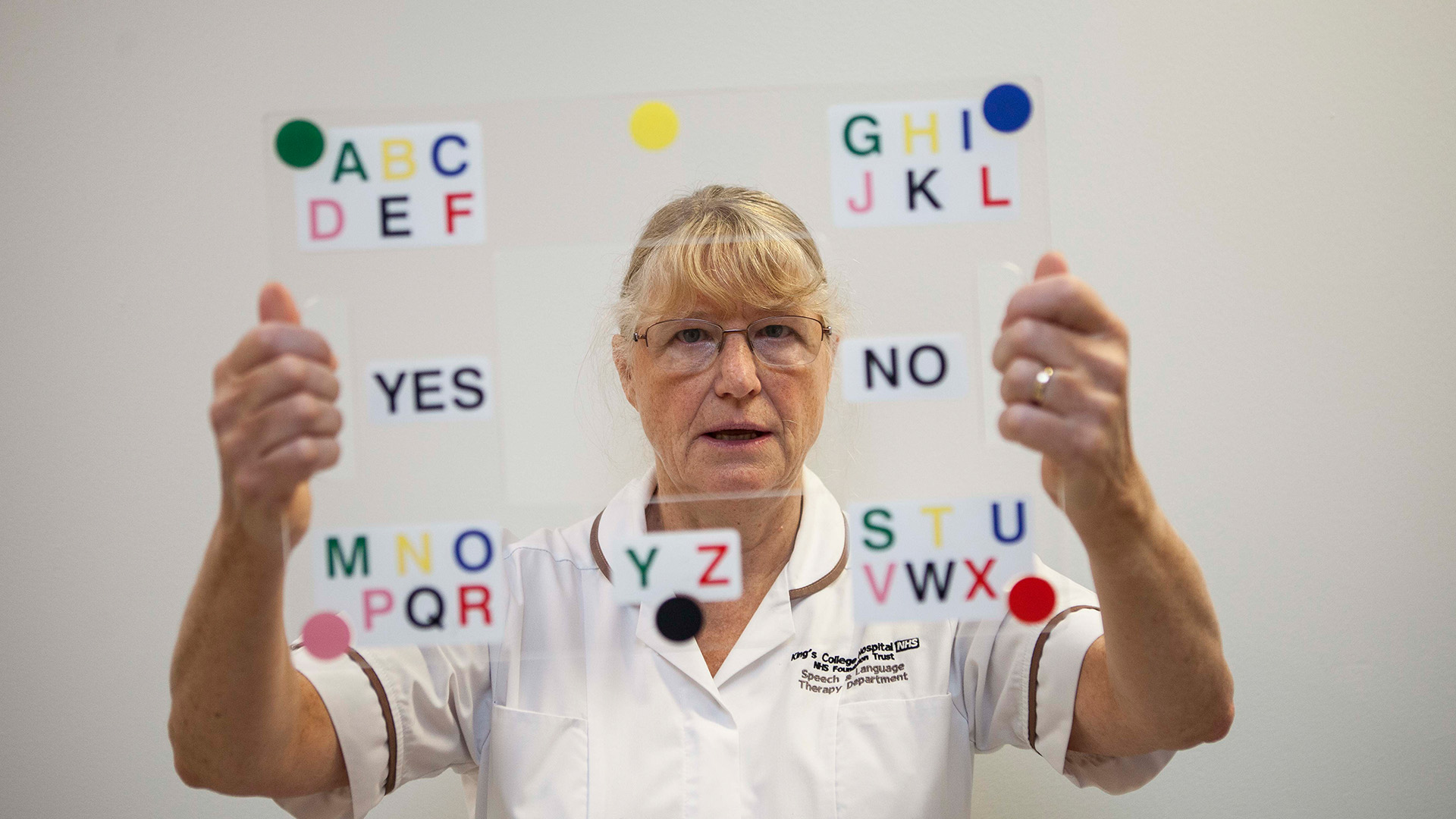 A speech and language therapist holding up an eye transfer frame