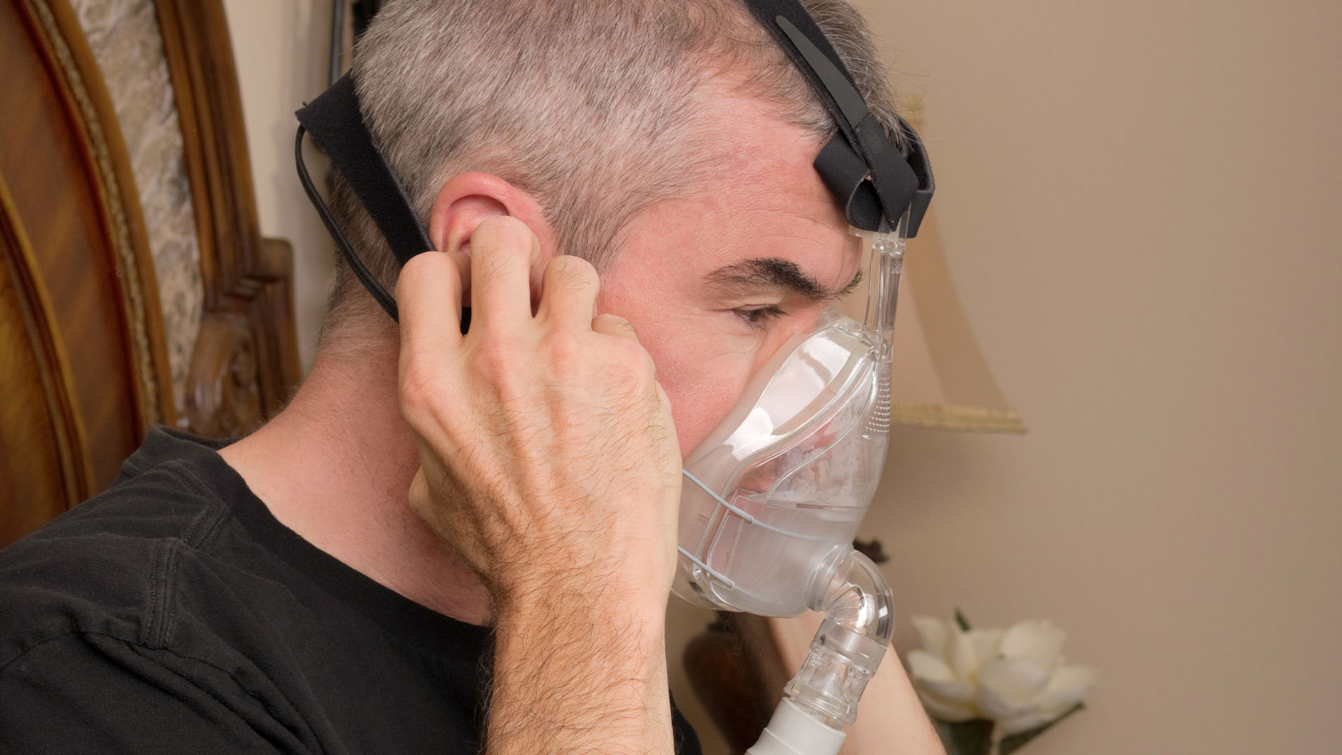 A man putting on an NIV mask