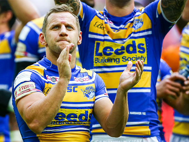 Rob Burrow clapping in the middle of the rugby stadium.