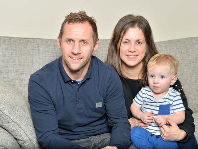 Rob burrow with wife and son sitting on a sofa.