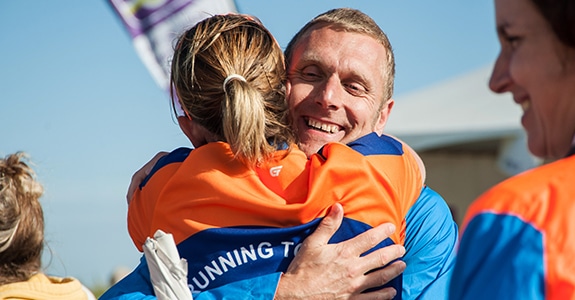 Two people hugging, in MND Association running clothes.