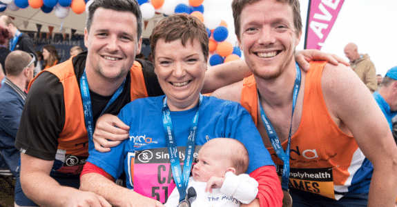 Supporter, Cath, sat in a wheelchair with baby, and her sons stood either side after completing a run event
