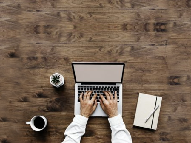 image of a person sitting at a desk with a laptop