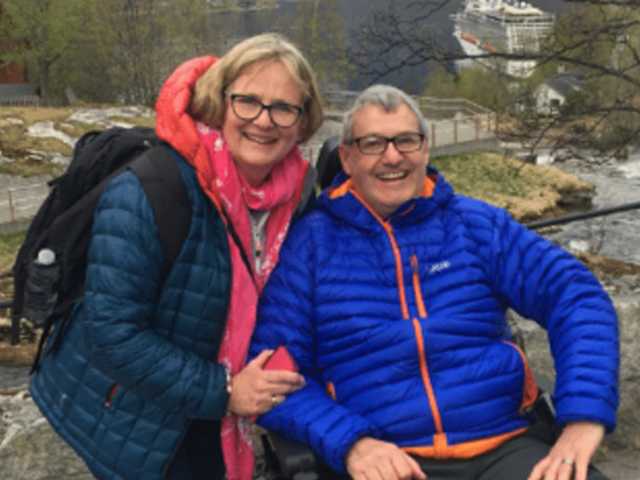 Two people outside hugging and smiling 