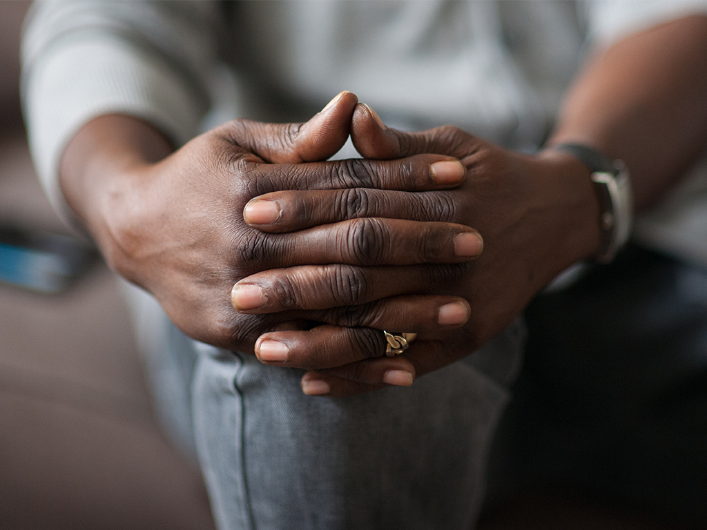 person clasping their hands over their knee