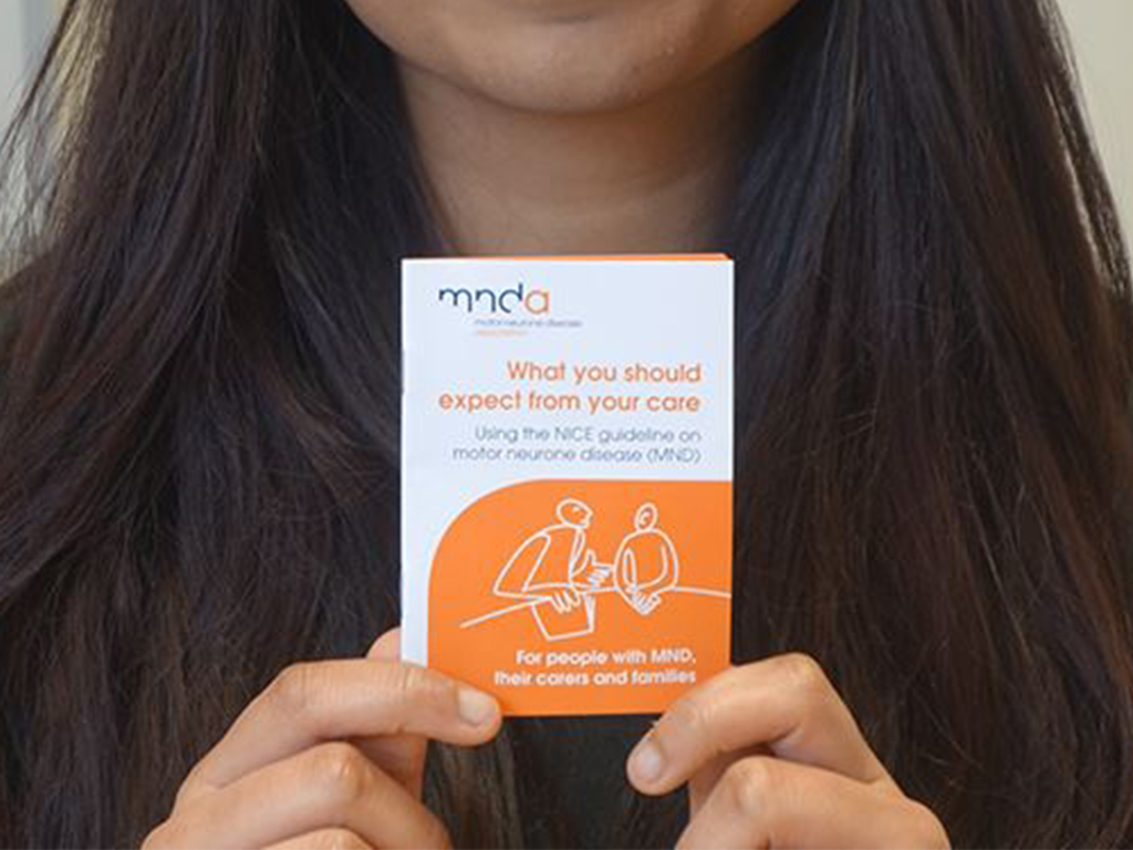 person holding a small booklet 