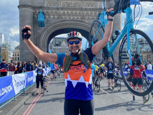 a man celebrating carrying a bicycle 