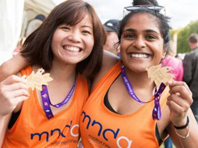 two people celebrating holding a medal