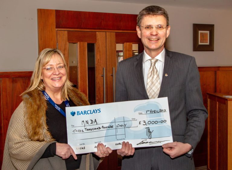 two people holding a cheque
