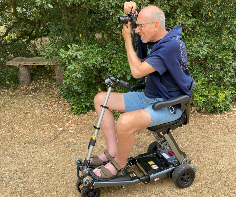 man taking pictures while using mobility scooter