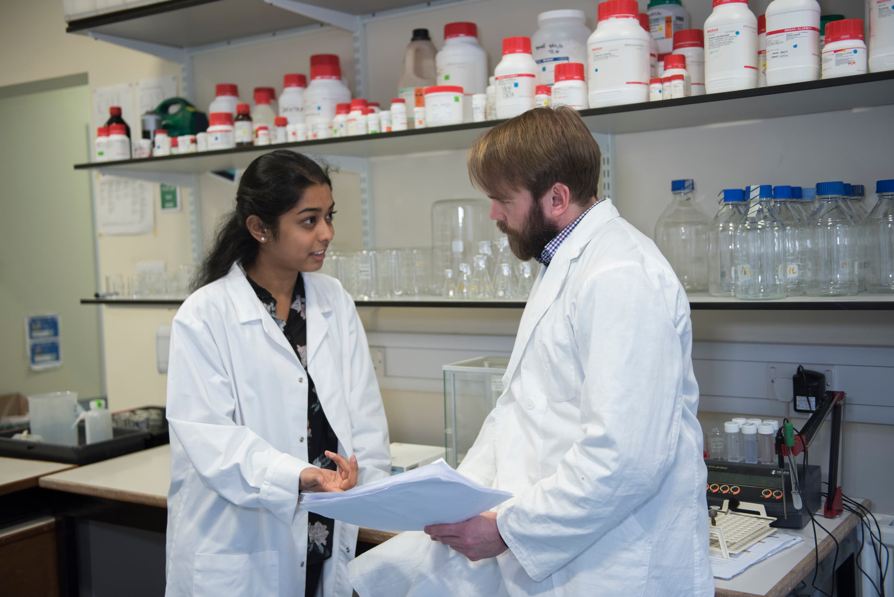 Two researchers in the lab at St Andrews, discussing work