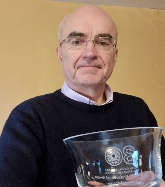 Richard Cave holding a glass award