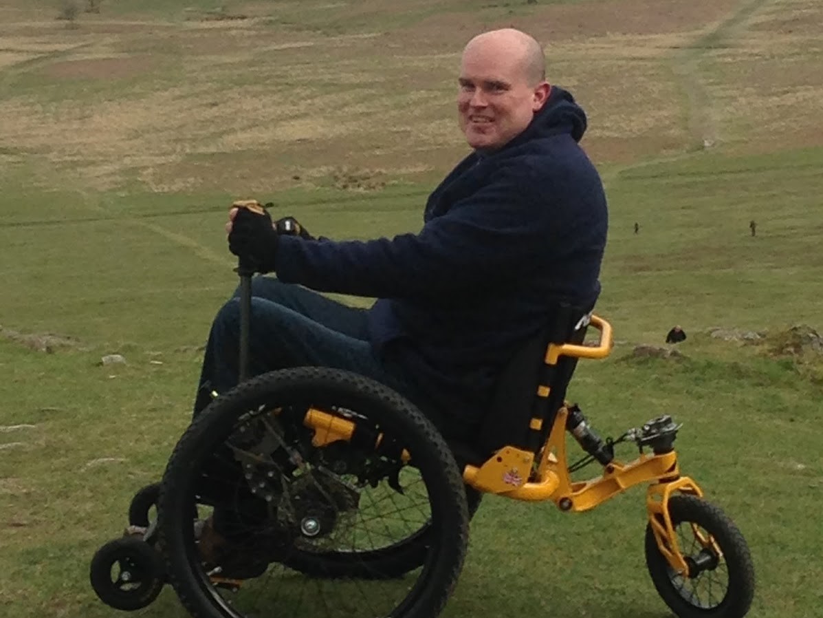 David in a wheelchair, in the countryside