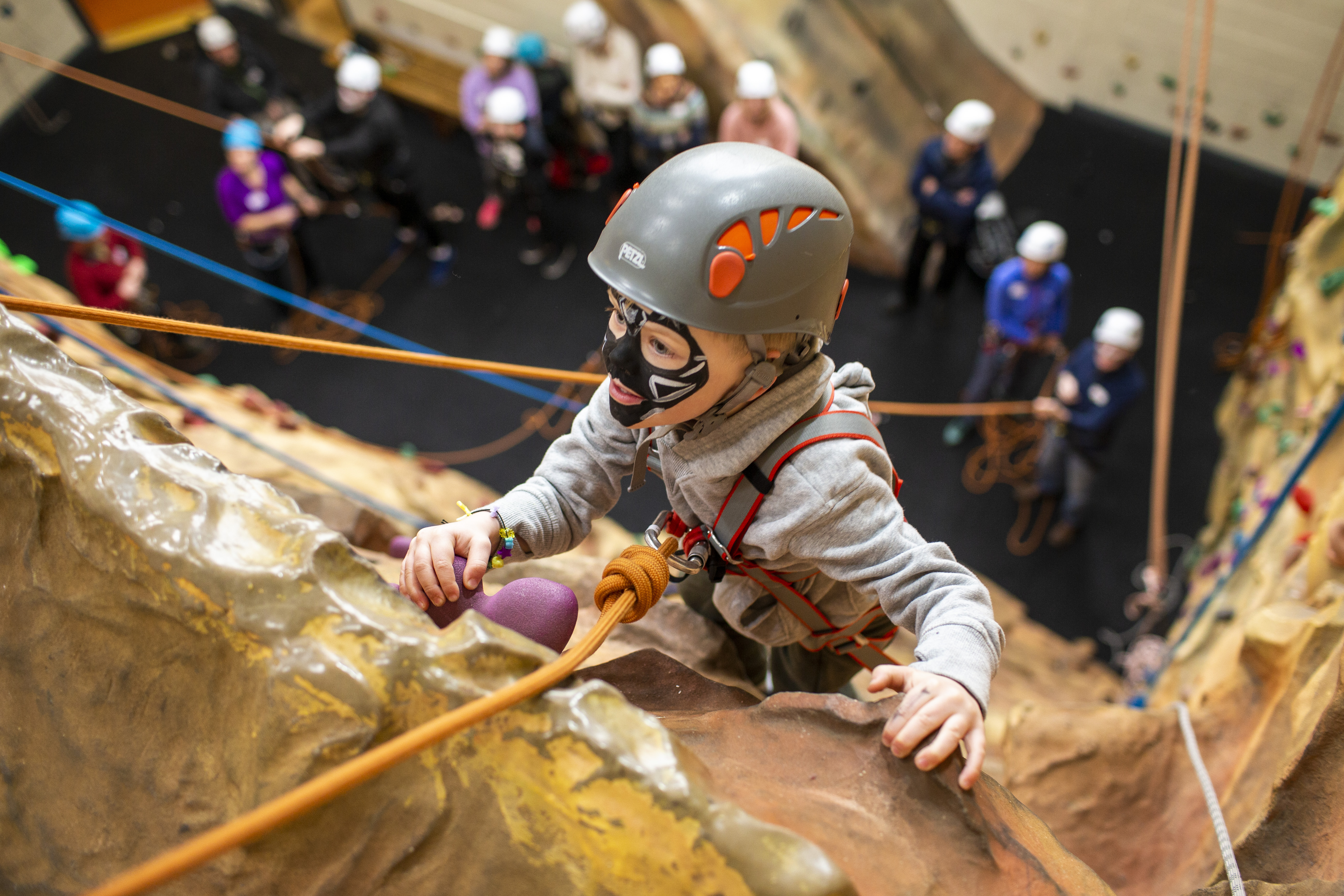 A child climbs a rock wall at the memory making day
