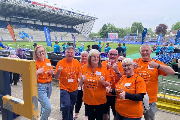 a group photo of people at an event wearing a mnd association t-shirt