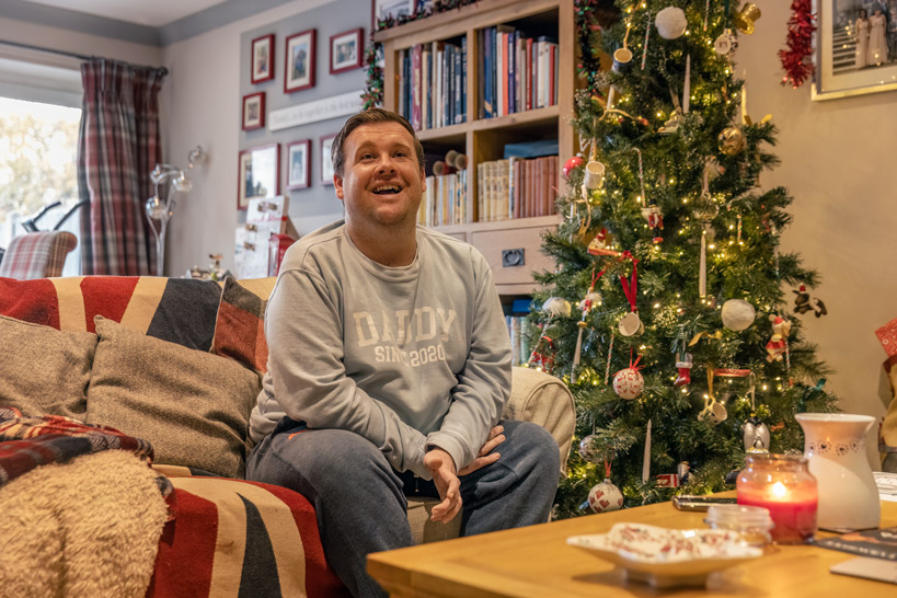 Sam smiling on sofa