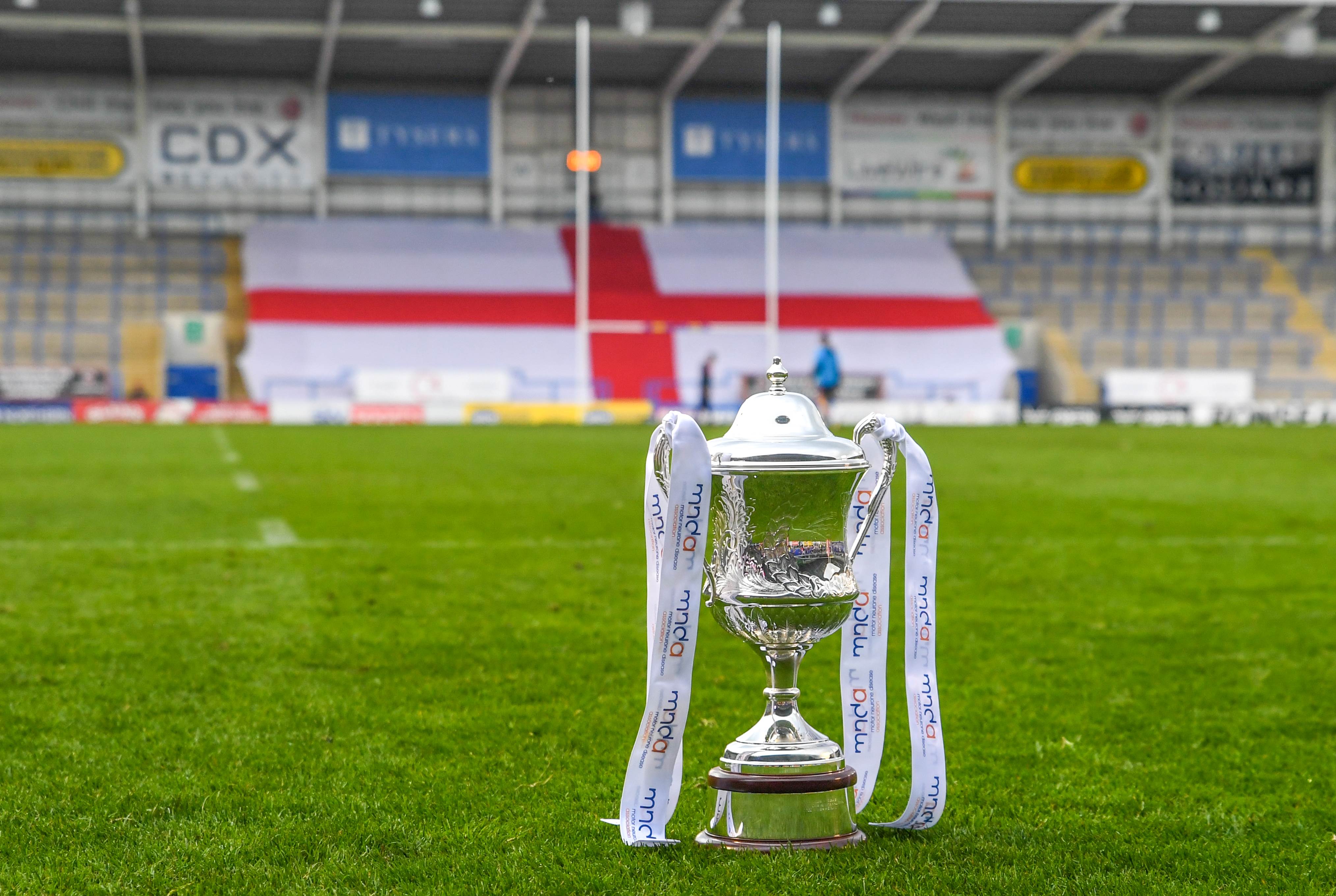 Image of a trophy with MND ribbons on a rugby pitch