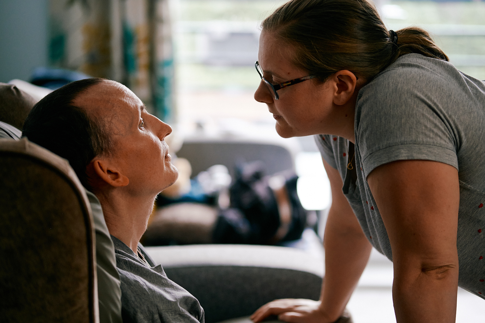 Mike, living with MND, and his partner Zoe in the living room.