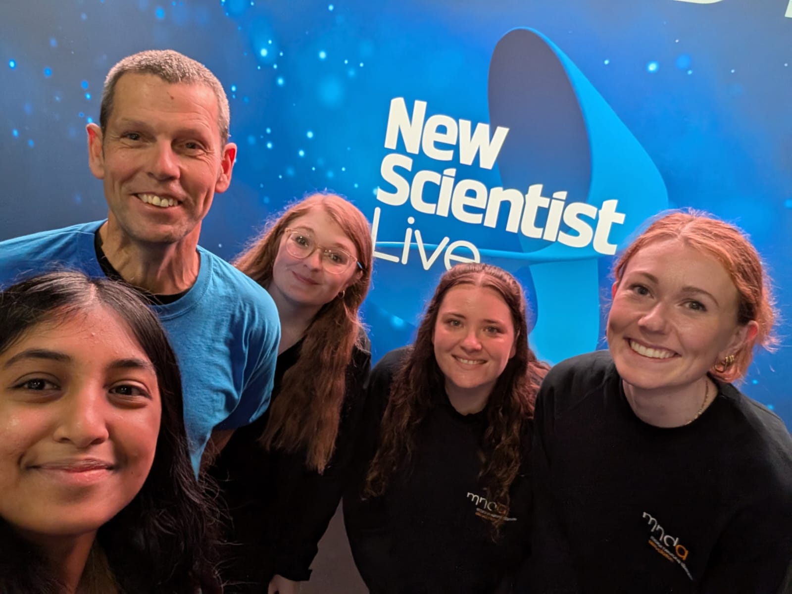 The research team in front of the New Scientist Live logo
