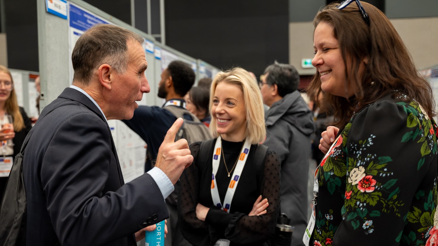 3 people chatting during a networking session at the Symposium.