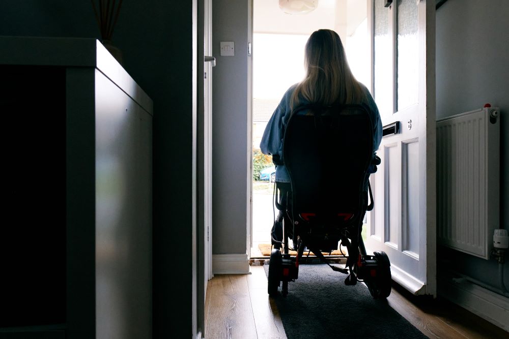 Person with MND in a doorway