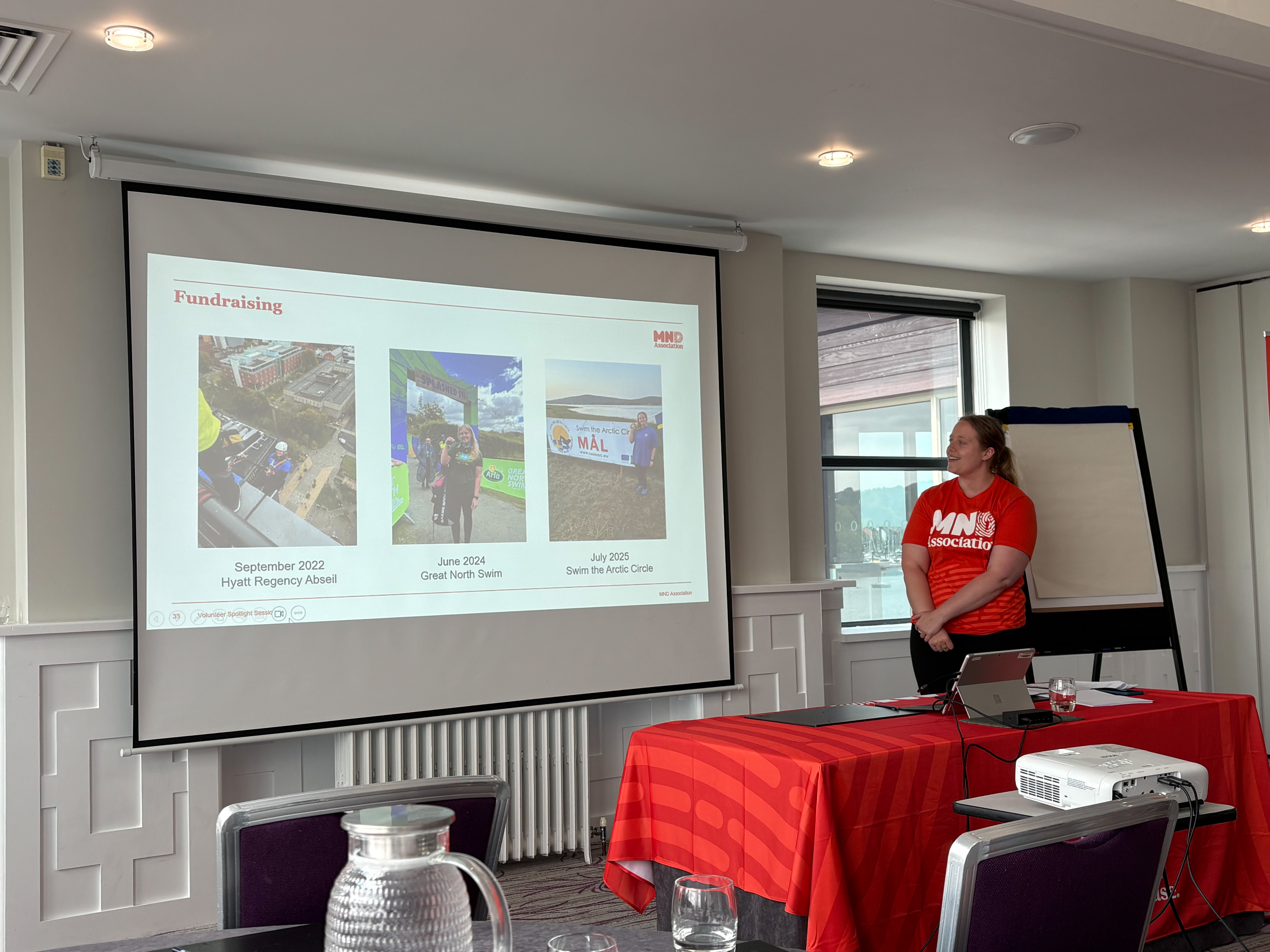 Volunteer presenting at an event by a screen