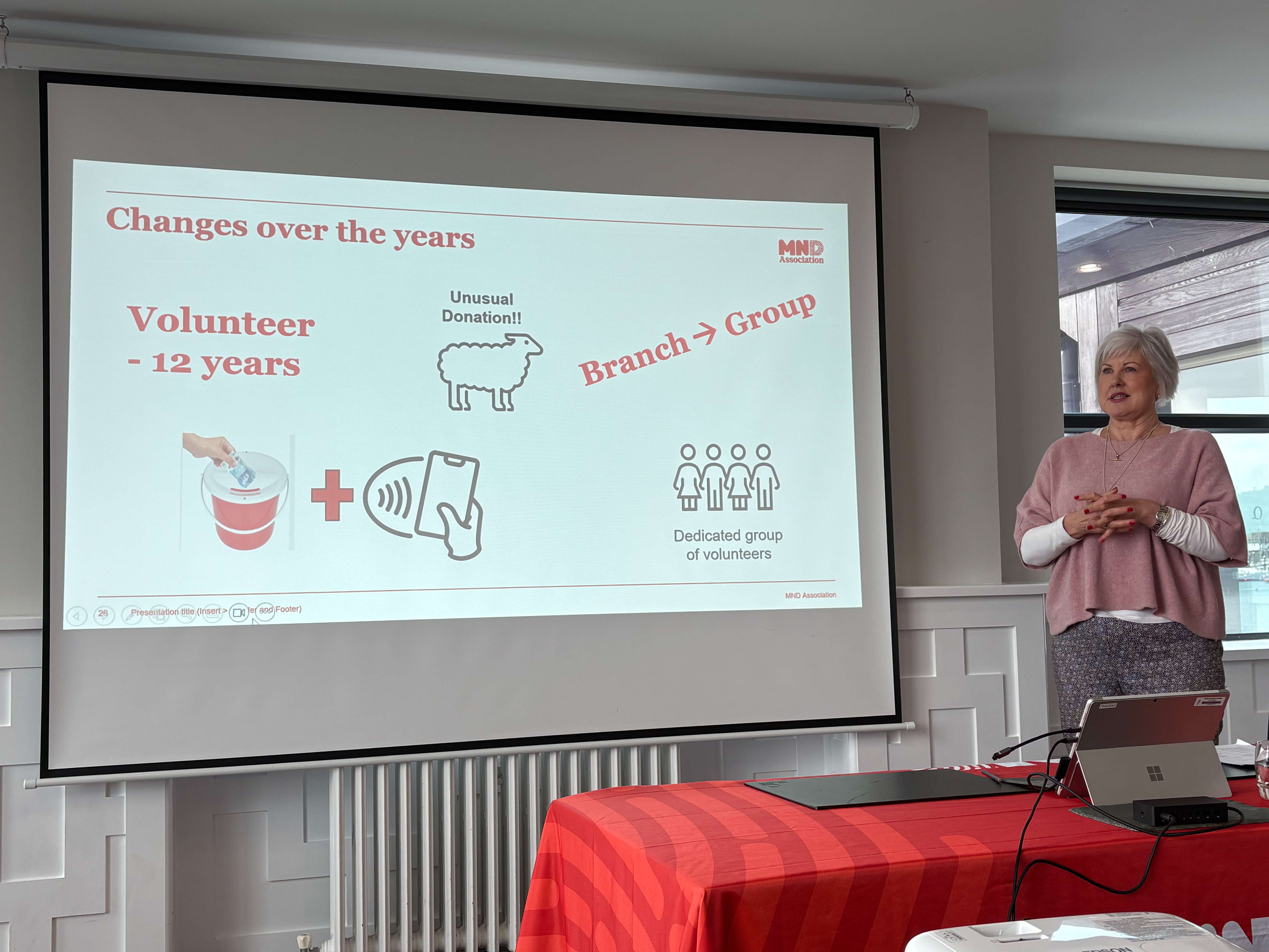 Volunteer presenting by a screen at an event