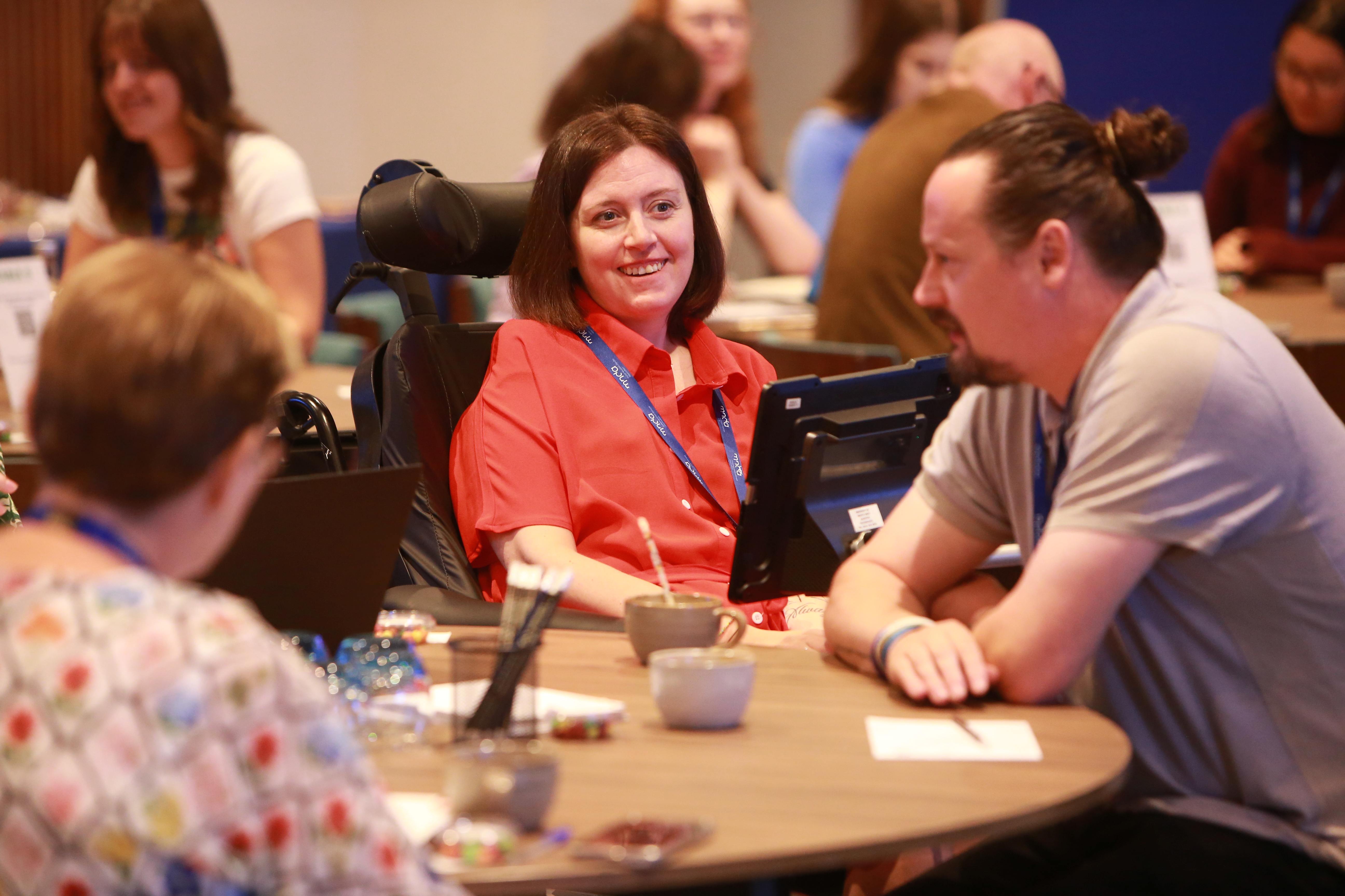 Anna and Martyn attending EnCouRage - Anna looks at Martyn during a table discussion, she smiles his way as he is in conversation with others