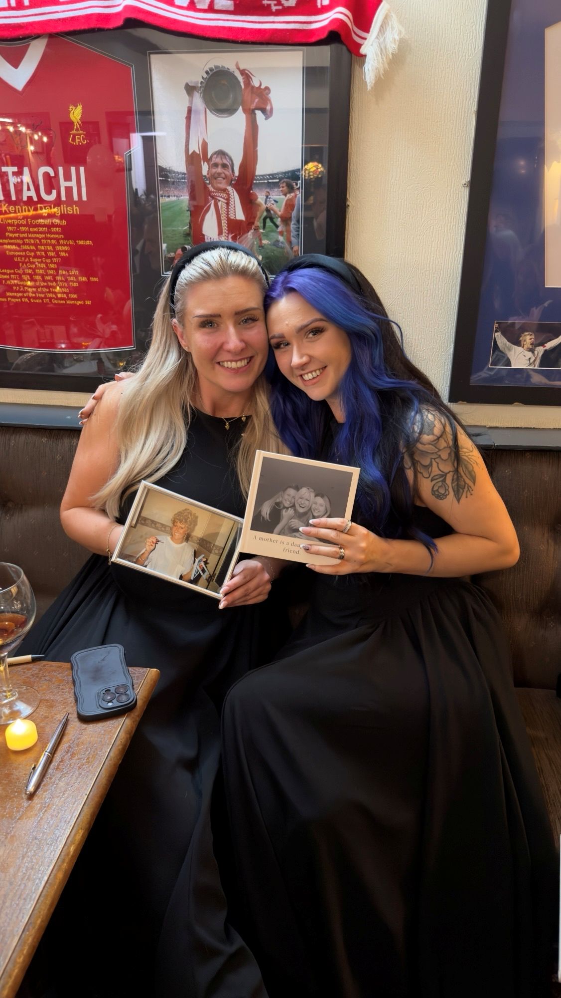 Courtney and Frankie at the pub during their mum's wake. They both hold a photo of their mum, Hayley