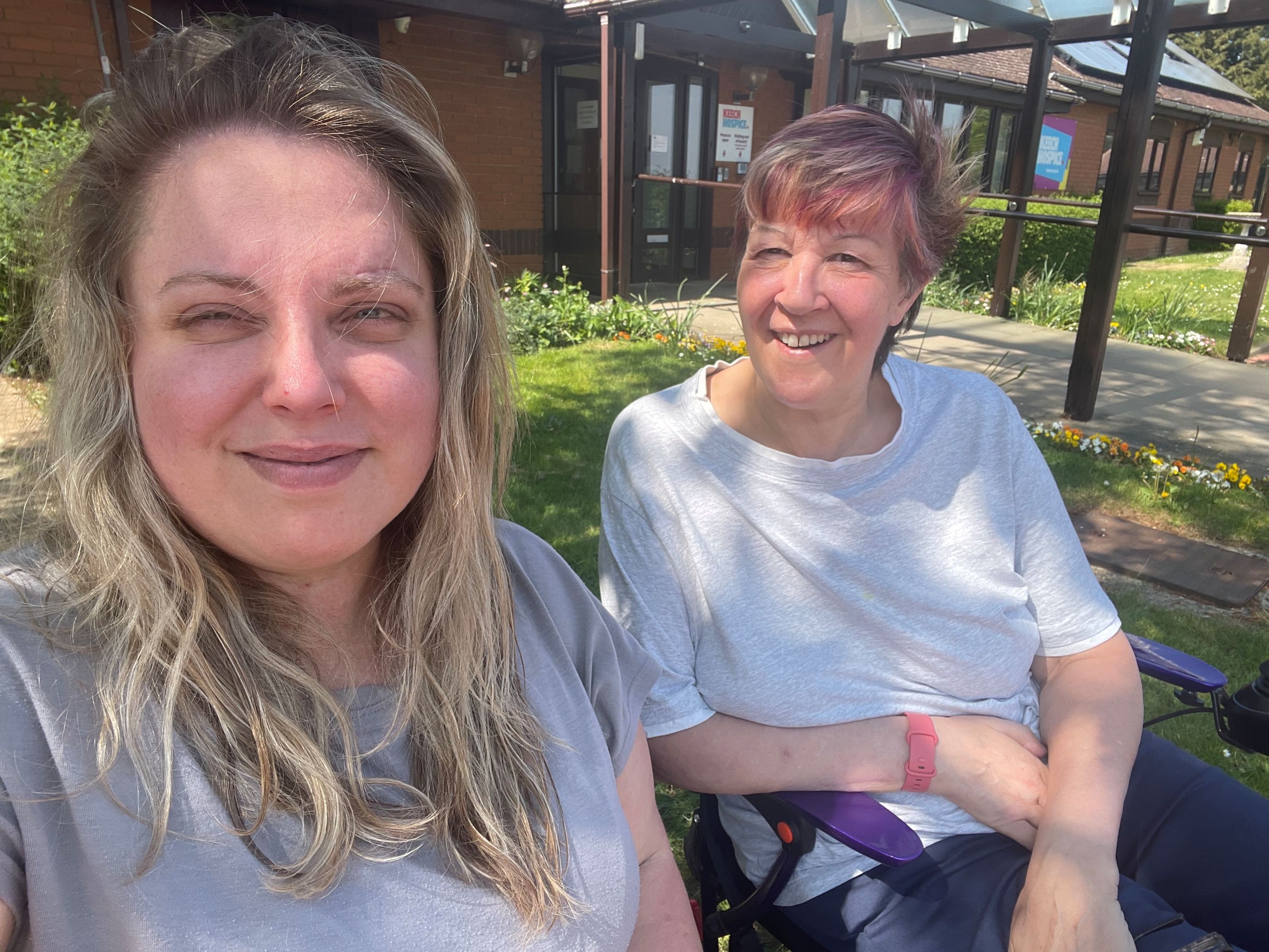 Louise with a friend sat outside Keech Hospice.