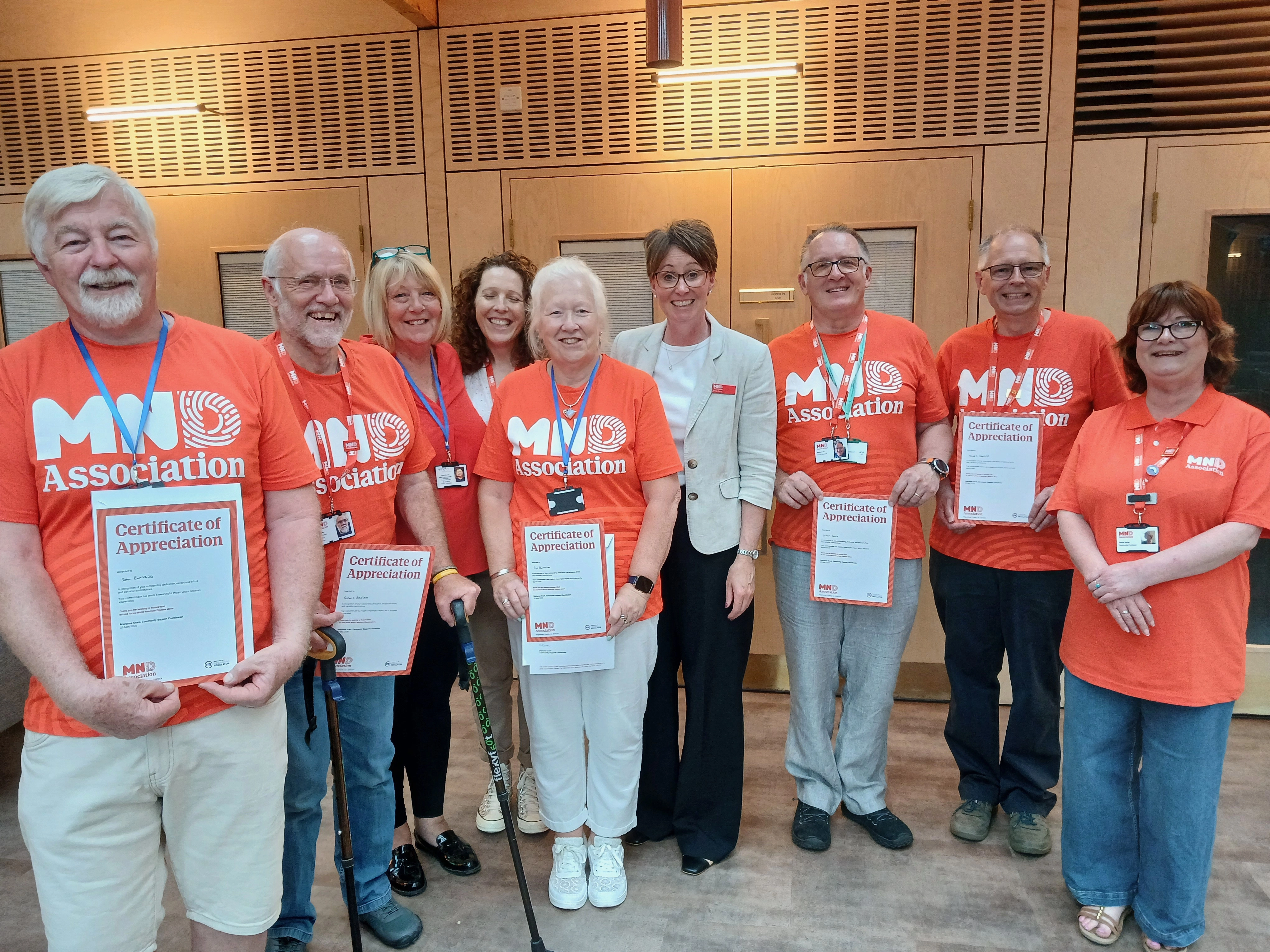 Volunteers smiling together with certificates