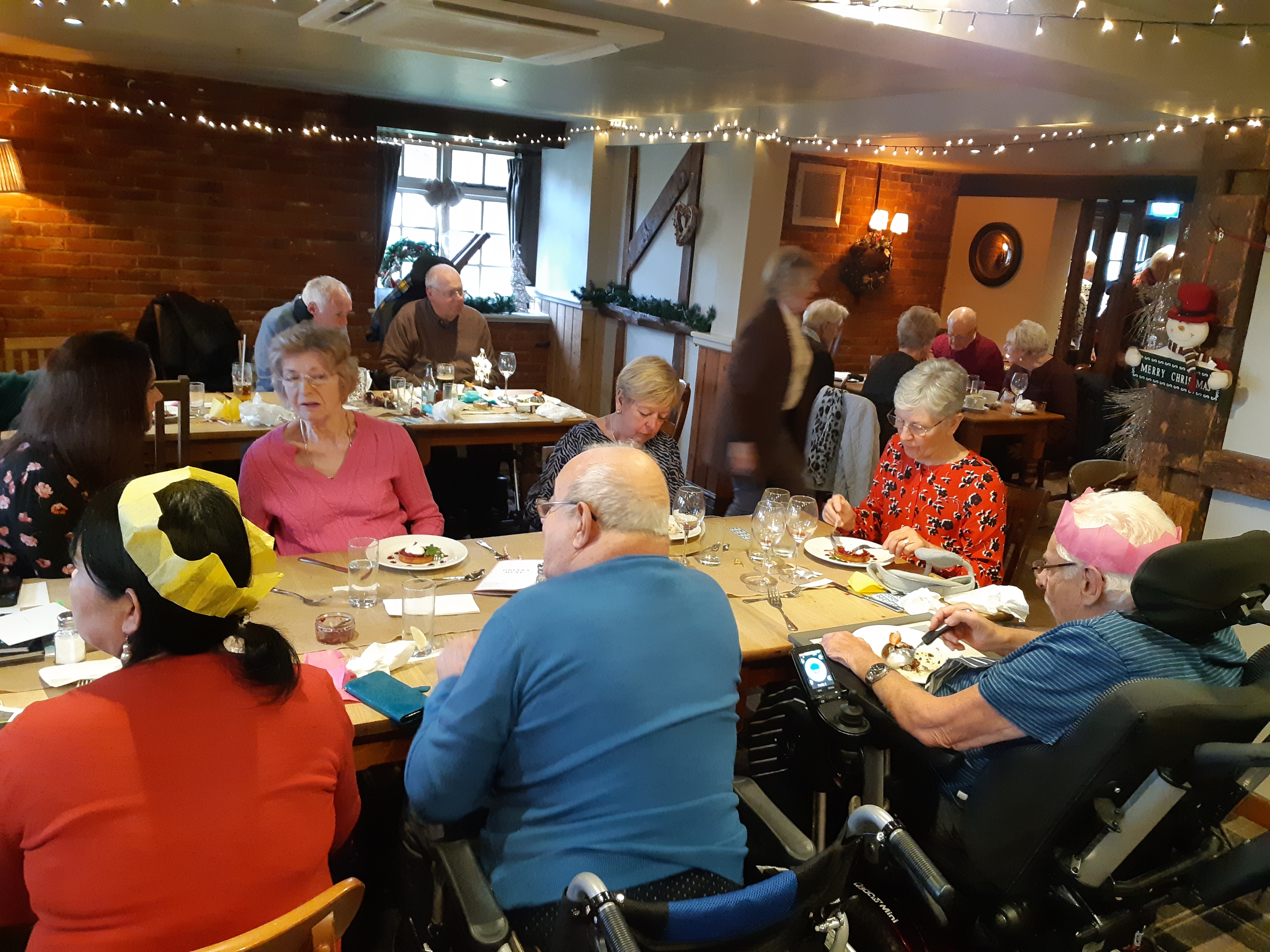 A group of people sat around a table with Christmas lunch 