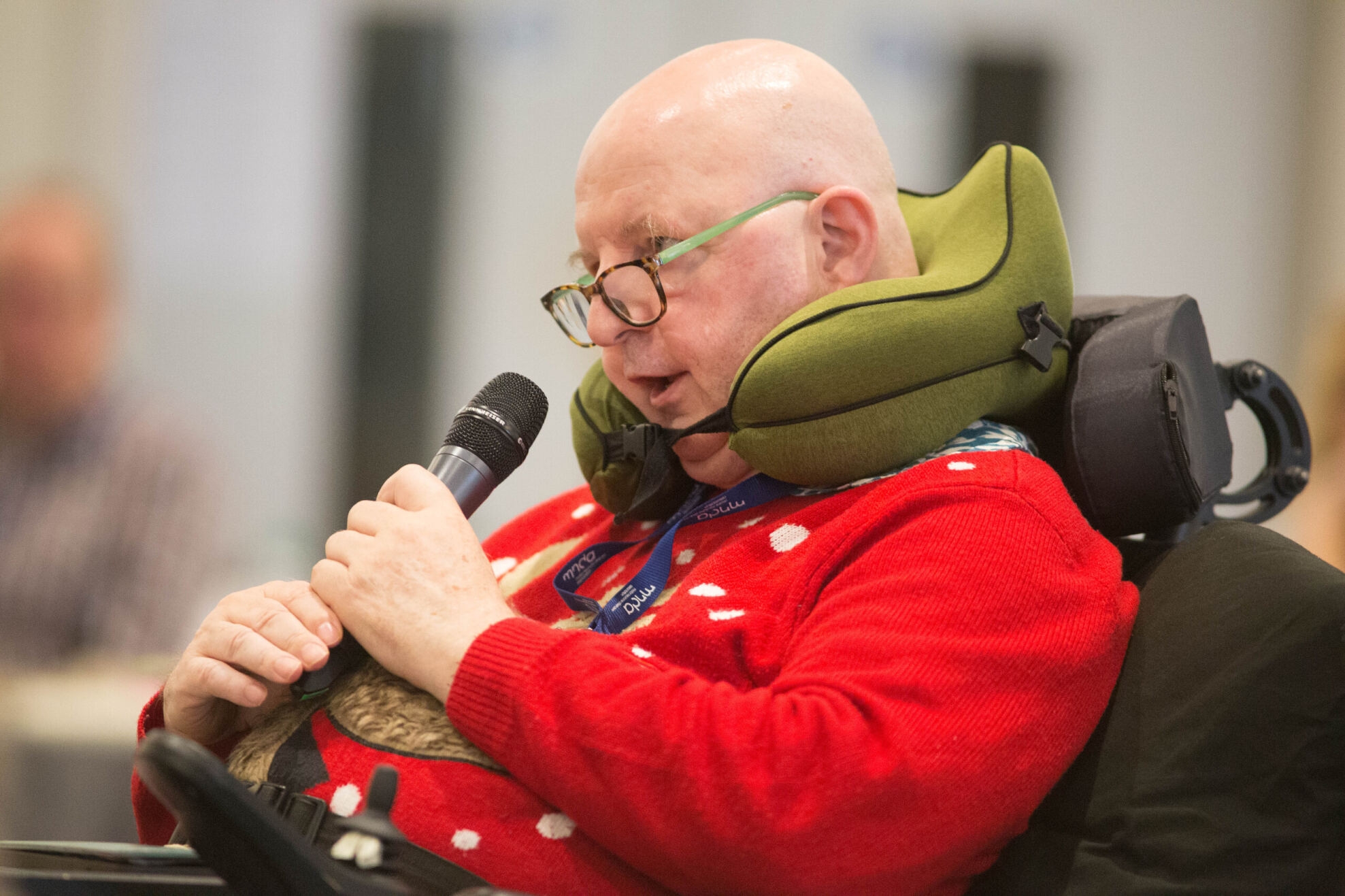 Person in a wheelchair holding a microphone