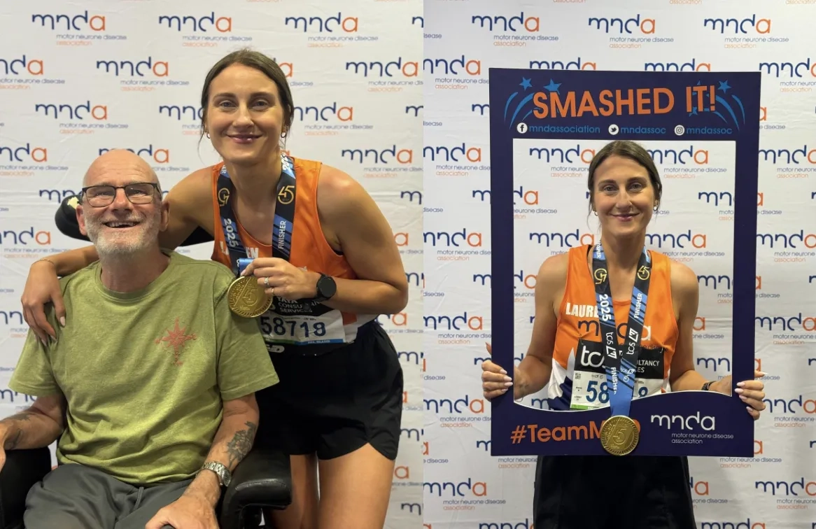 Lauren stood smiling in front of an MND Association banner