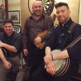 Patrick with band mates - holding a banjo