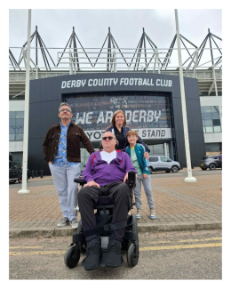Liam in his power wheelchair outside the Derby County football ground with friends.