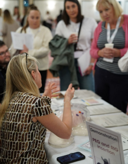 Health and social care professionals gathered around a table for a demonstration by another professional
