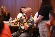 Person with MND speaking into a microphone.