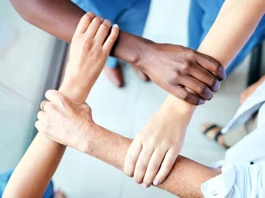 Healthcare workers' hands interlocked