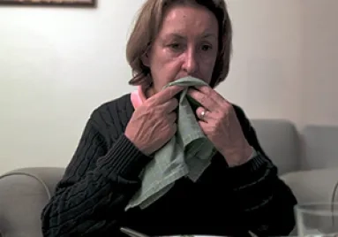 A woman wiping her mouth with a napkin
