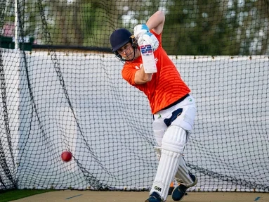 someone playing cricket wearing a MND t-shirt