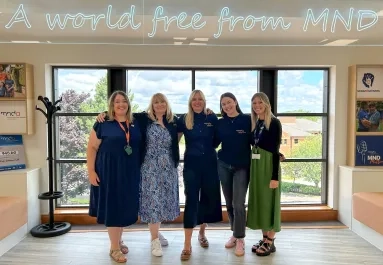 Tribute Fund team under 'A world free from MND' sign.