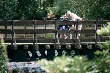Person with MND with friend on a bridge
