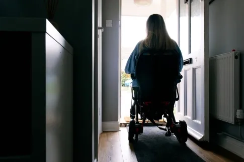 Person with MND in a doorway