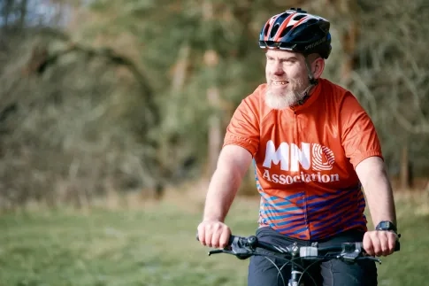 a cyclist wearing a MND Association jersey