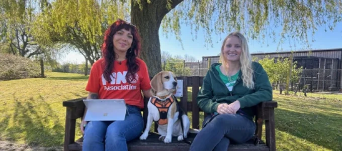 Domonique and Lizzie sitting with a dog on a bench