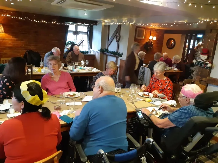 A group of people sat around a table with Christmas lunch