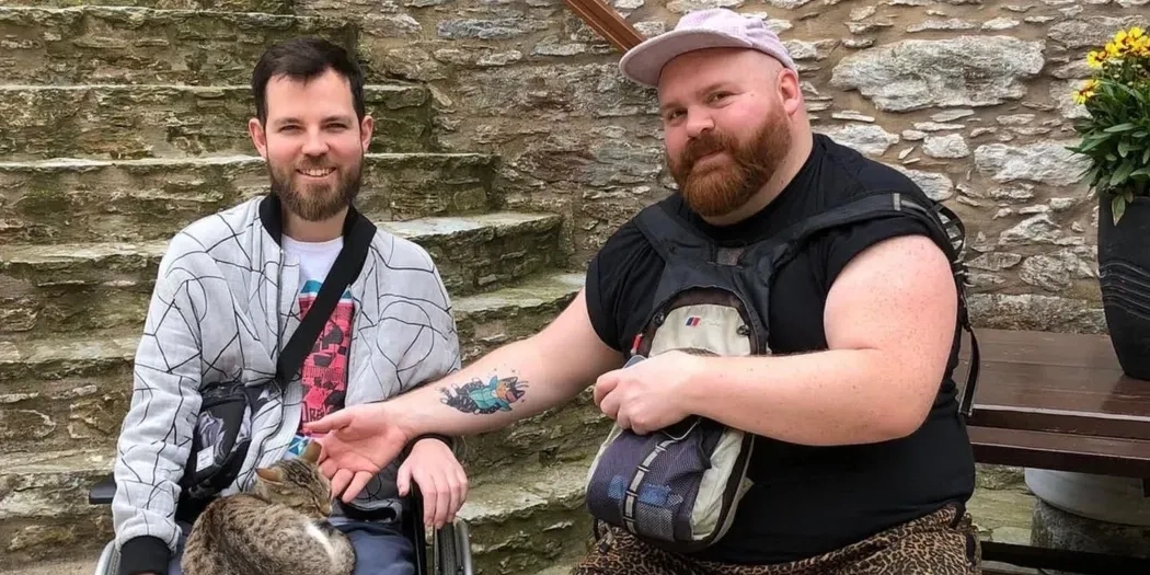 Two men on holiday smiling to the camera